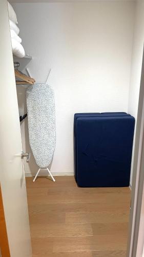 a blue suitcase sitting in the corner of a room at グランディオーソ中野富士見町 in Tokyo