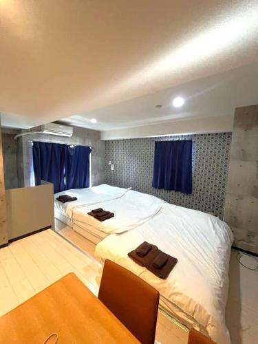 a bedroom with two beds with towels on them at グランディオーソ中野富士見町 in Tokyo
