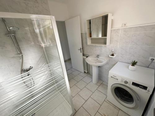 une salle de bain avec une machine à laver et un lavabo dans l'établissement Haut de villa, pleine vue mer, à Saint-Mandrier-sur-Mer