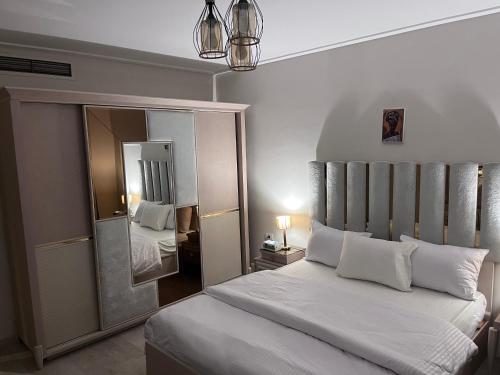 a bedroom with a large bed and a mirror at A Luxury Hotel Appartment at NEW GIZA Imperial Compound قريبة جدا للمتحف المصري الجديد in Abū Rawwāsh