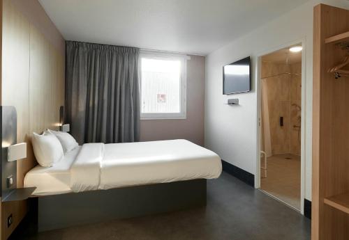 a hotel room with a bed and a television at B&B HOTEL Paris Nord Gonesse Parc des Expos in Gonesse