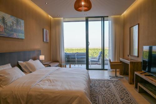 a hotel room with a large bed and a television at Al Malfa Resort & Hotel in Unayzah