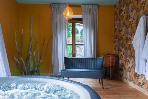 a tub in a room with a chair and a window at HONEY Moonspa in San Pellegrino Terme