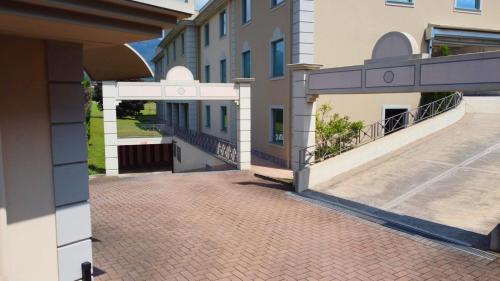 a building with a brick walkway and a balcony at Motel Soignè in Mapello