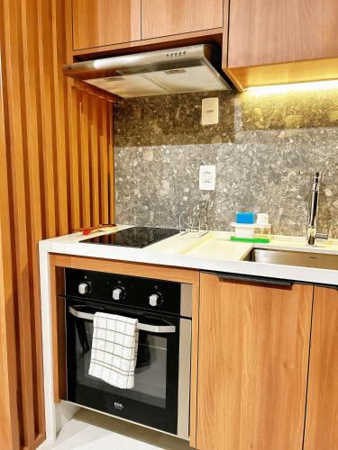 a kitchen with a stove and a sink at Estúdio sofisticado no centro do Rio com vaga de garagem in Rio de Janeiro