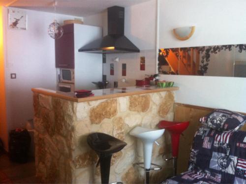 - une cuisine avec un comptoir en pierre et un bar dans l'établissement Le Thabor, à Modane