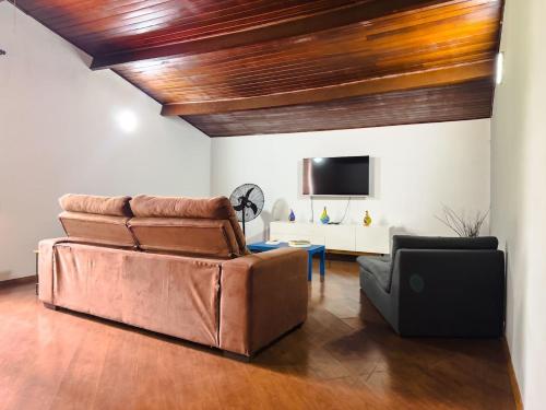 a living room with a couch and a tv at Casa espaçosa a apenas 30 minutos de SP in Sao Paulo