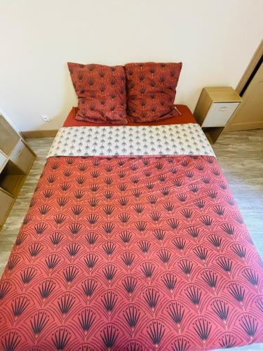 a bedroom with a pink bed with red pillows at Le Studio du Vieux-Mans - 2 guests - Wifi in Le Mans