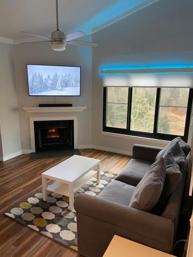 a living room with a couch and a tv at Modern Condo with Ski In & Ski Out - Silver Creek Lodge, Snowshoe in Snowshoe