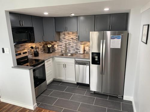a kitchen with black cabinets and a stainless steel refrigerator at Modern Condo with Ski In & Ski Out - Silver Creek Lodge, Snowshoe in Snowshoe