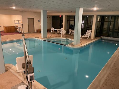 a large blue swimming pool with chairs and tables at Modern Condo with Ski In & Ski Out - Silver Creek Lodge, Snowshoe in Snowshoe