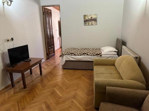 a living room with a couch and a table and a bed at Hotel Cattaleya in Batumi
