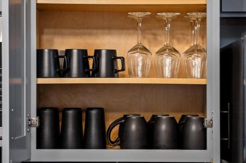 a cupboard filled with black pots and glasses at Joliet Cozy Oasis 4BR in Joliet