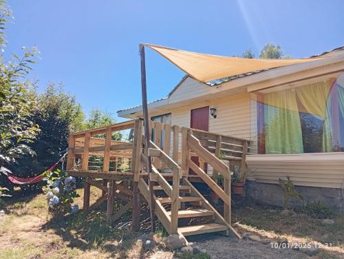 a house with a large wooden deck in front of it at Ale in Villarrica