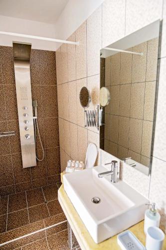 a bathroom with a sink and a mirror at Vournelis Beach Hotel and Spa in Iraklitsa