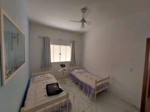 a bedroom with two beds and a window at Cantinho do sossego in Ilhéus