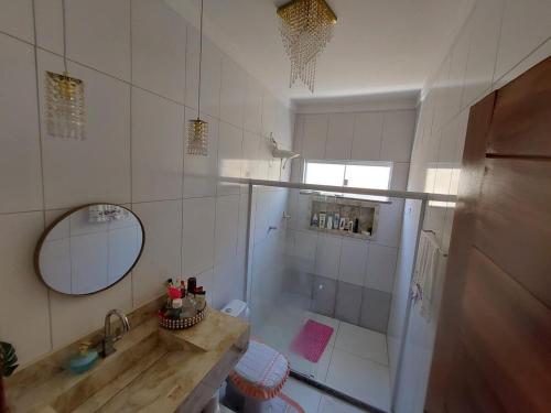 a bathroom with a shower and a sink and a mirror at Cantinho do sossego in Ilhéus