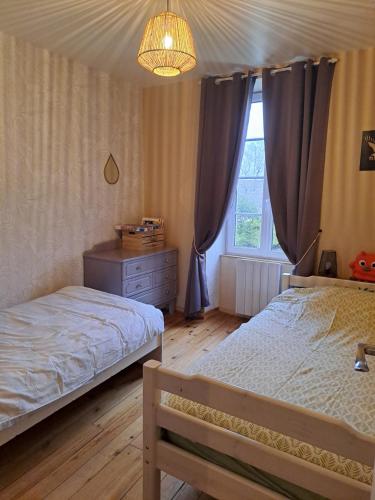 Un dormitorio con dos camas y una ventana. en Gîte 4 pers avec option sauna- Classé 3 étoiles- Sud charente, en Lagarde-sur-le-Né