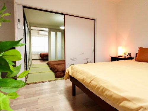 a bedroom with a bed and a large mirror at An-shao-ya安嶼屋 8minutes walk to JR Teradacho Loop Line Station 13minutes walk to Tennoji Mall in Osaka