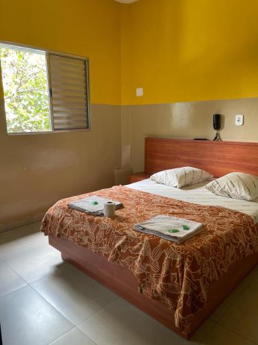 a bedroom with a bed with two towels and a window at Hotel Gasometro in São Paulo