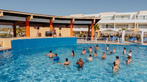 a group of people in the water at a swimming pool at Rosa Agustina Guanaqueros Resort in Guanaqueros