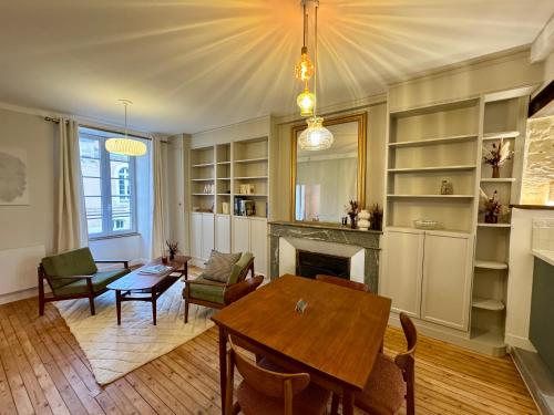 un salon avec une table et une cheminée dans l'établissement Le Napoleon - T3 Luxueux, à La Roche-sur-Yon