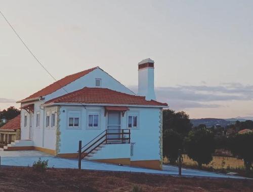 a small white house with a chimney and a staircase at Casa dos pássaros in Carril