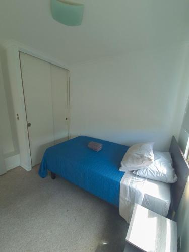 a bedroom with a bed with blue sheets and pillows at Depto, Condominio Portal del Sol in Arica