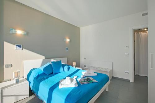 a bedroom with a blue bed with towels on it at Sogno Sul Lago Lake Front - Happy Rentals in Laveno-Mombello