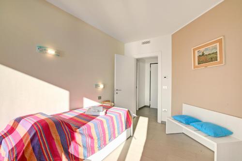 a white bedroom with a bed and blue pillows at Sogno Sul Lago Lake Front - Happy Rentals in Laveno-Mombello