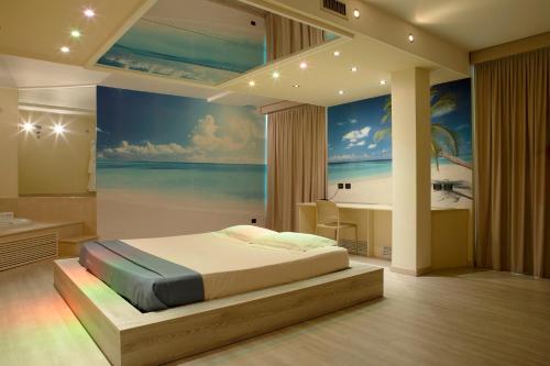 a bedroom with a bed and a painting of the ocean at Motel Soignè in Mapello