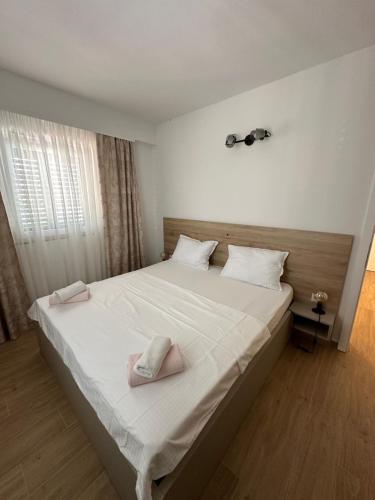 a bedroom with a large white bed with two towels on it at Apartmani Svemir in Drage