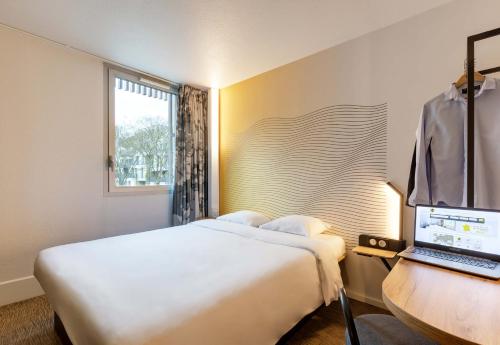a hotel room with a bed and a laptop on a desk at B&B HOTEL Lille Centre Grand Palais in Lille