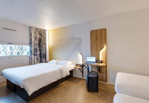 a hotel room with a bed and a laptop on a desk at B&B HOTEL Lille Centre Grand Palais in Lille