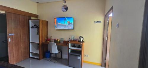 a room with a desk and a table with a chair at Holi Homestay Trawas in Trawas