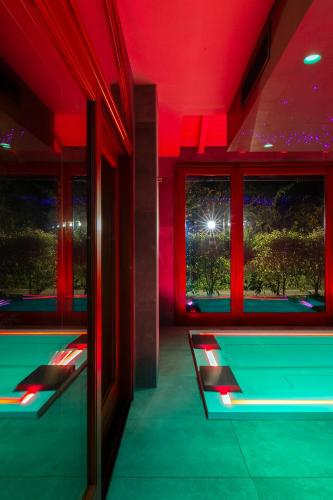 a room with red lighting and a table and windows at Mulino di Casa Sforza Suites and Spa in Basilicanova