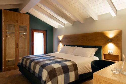 a bedroom with a bed with a checkered blanket at Mulino di Casa Sforza Suites and Spa in Basilicanova