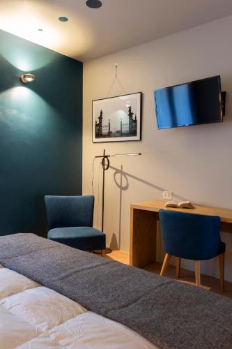 a bedroom with a bed and two chairs and a desk at Mulino di Casa Sforza Suites and Spa in Basilicanova