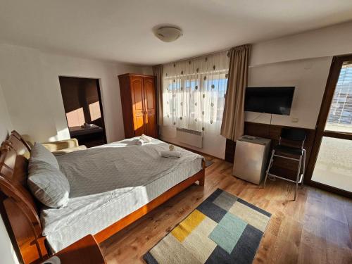 a bedroom with a bed and a flat screen tv at Prime Apartments in Bansko