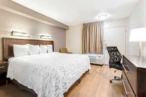 a hotel room with a bed and a desk at Red Roof Inn PLUS+ Mt Pleasant - Patriots Point in Charleston