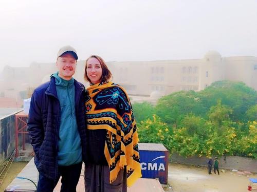 a man and a woman standing on top of a building at The Street homestay in Agra