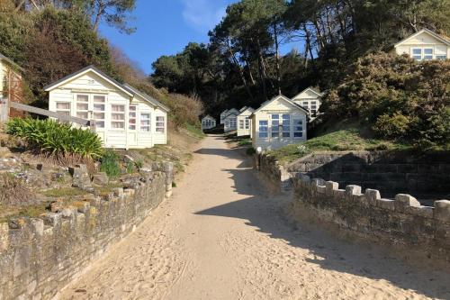 a row of white houses on a dirt road at Canford Cliffs Apartment in Poole
