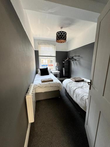 a bedroom with two beds and a window at Canford Cliffs Apartment in Poole