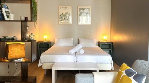 a bedroom with a white bed and a couch at 5ème Ciel - Première Conciergerie in Montpellier