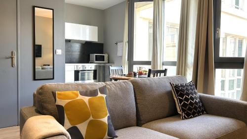 un salon avec un canapé et une cuisine dans l'établissement 5ème Ciel - Première Conciergerie, à Montpellier