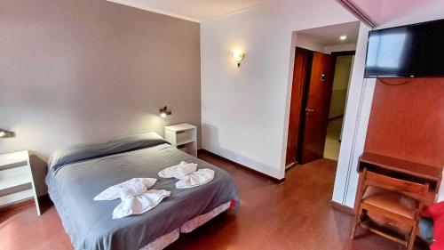 a bedroom with a bed with towels on it at Hotel Cosmos in Mar del Plata