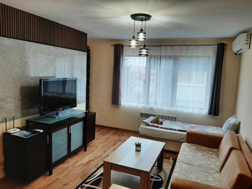 a living room with a couch and a flat screen tv at Prime Apartments in Bansko