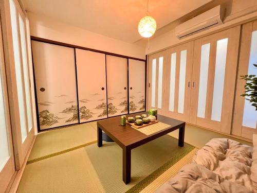 a living room with a table and a couch at An-shao-ya安嶼屋 8minutes walk to JR Teradacho Loop Line Station 13minutes walk to Tennoji Mall in Osaka