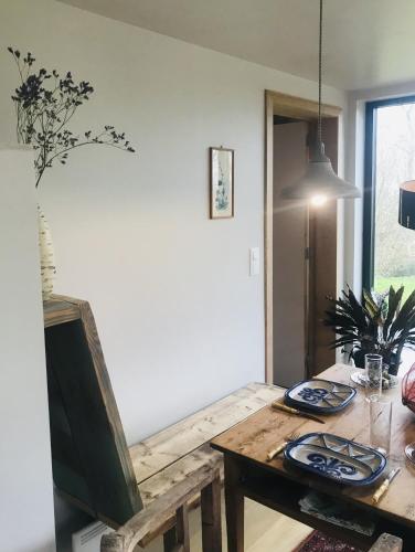 a dining room with a wooden table with plates on it at Panacée Guesthouses in Ronse