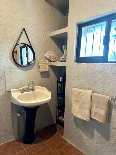 a bathroom with a sink and a mirror and towels at Habitaciones Dos Antonios in Puerto Vallarta